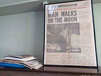 Framed Toronto Daily Star front page and stack of additional print items