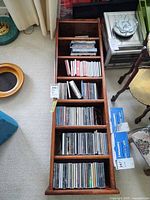 Wooden CD shelf lying flat, filled with CDs