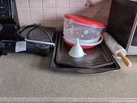Overall lot: cooktop, baking sheets, containers, funnel, rolling pin