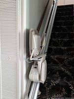 Full view of folded Harmar SL600DC stair lift mounted on staircase rail