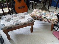 Both footstools side by side showing upholstery and wooden legs