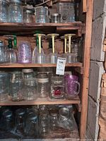 Shelved assortment of mason jars, stemware, purple mug and square jar