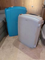 Turquoise blue and light gray Samsonite hardside suitcases standing upright
