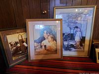 Group shot of all three framed children prints leaning against wall