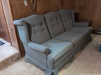 Full view of sofa showing wingback sides, skirt, three seat cushions