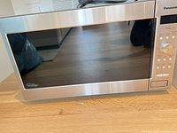 Front view of Panasonic stainless steel microwave showing door and exterior condition