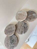 Five round marble coasters lying flat