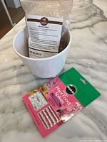 Pot, orchid bark bag, and plant food spikes on countertop