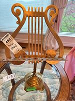 Full view of brass lyre-shaped music stand on table
