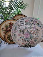 Front view showing three decorative plates on stands