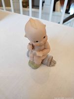 Front view of seated baby figurine on scroll