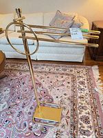 Full view of brass towel rack showing three arms and base