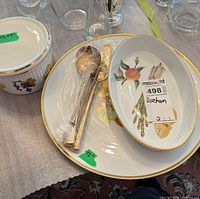 Round platter, oval baker, ribbed soufflé dish, and bundled gold-tone utensils