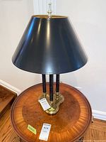 Full view of lamp on wooden table showing shade, columns and base
