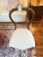 Front view of balloon back chair showing wood frame and upholstered seat