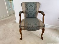 Front view of armchair showing upholstery pattern and wood frame