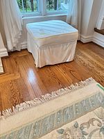Ottoman beside window showing overall shape and skirt