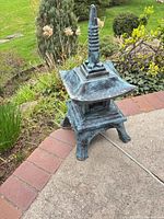 Full view of concrete pagoda ornament on patio showing overall form and patina