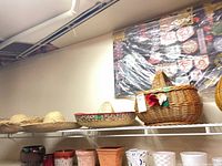 Top shelf showing multiple straw sombreros and wicker basket