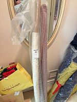 Cream organza and red-pink striped mesh rolls on cardboard tubes in plastic sleeve