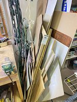 Stack of assorted plywood, MDF, corrugated plastic and cardboard sheets with bundle of extension cords
