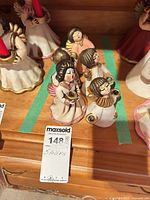 Five small porcelain angel candle holders on shelf