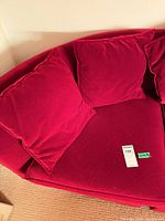 Overall view of red velvet sofa section with two loose back pillows and seat cushion
