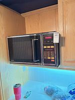 Front view of Toshiba microwave mounted under cabinet showing control panel and handle