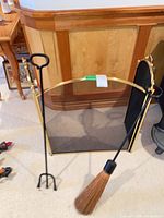 fireplace screen standing upright with both tools leaned in front