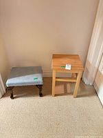 Footstool and side table together against wall