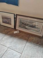 Overall view of both framed boat prints on floor
