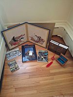 Group view of bifold art, travel and language books, trinket box and tassel