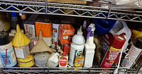 Shelved assortment of auto fluids, insect sprays, funnels, tins and aerosols