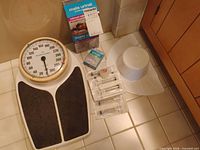 Group shot of scale, boxed urinal, tape, syringes, walker glides