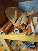 Three copper rolls on shelf with brown paper wrap, cardboard cores visible