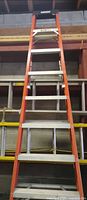 Front view of orange fiberglass step ladder showing aluminum steps and black top cap