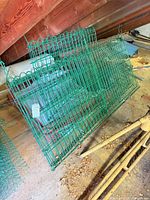 Stack of green vinyl-coated fence panels and rolled fencing