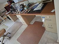Overall view of the long brown Formica countertop desk resting on two beige metal drawer pedestals