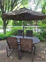Full patio set showing table, four chairs, umbrella