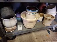 shelf holding assorted planters and saucers