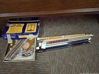 Overview showing box labeled Imperial Cue and Ball Rack and four pool cue sticks
