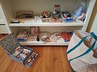 Overall view of shelving with sewing box, buttons, hoops, tools and tote