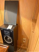 Front view of Boston Acoustics A40 speaker with grille partially removed showing drivers
