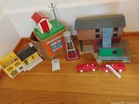 Full lot overview showing gateman on box, water tower, brown building, vehicles and house