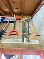All tools laid on work platform including crosscut saw, edger, metal shovel and blue shovel
