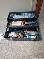Overview of open blue metal case with visible medical instruments and supplies