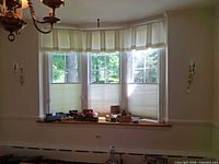 Bay window view showing both brass wall sconces installed