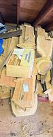 Stack of assorted wood boards, slabs and offcuts on floor