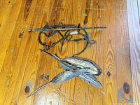 Assorted wrought iron brackets and two metal feathers on floor