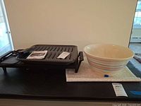 Yellow ware bowl beside Toastmaster griddle base and broiler pan